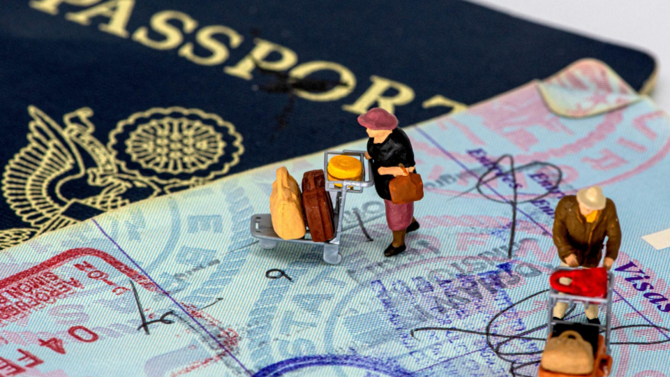 Des figurines de personnes changeant de pays, avec des passeports et de visas en fond